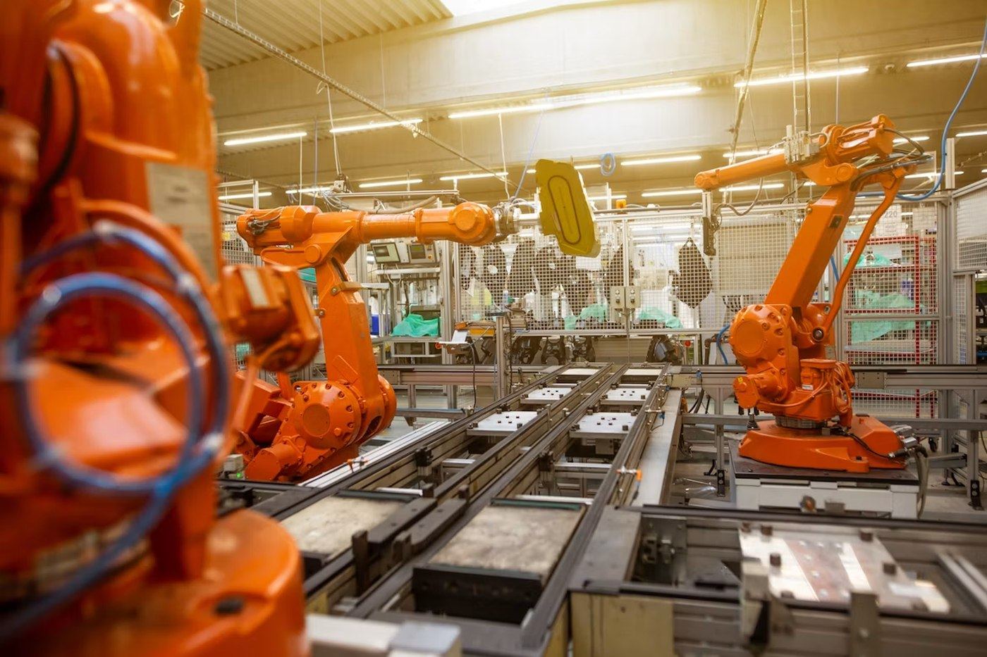 Automatiseret produktionslinje med robotceller og transportbånd